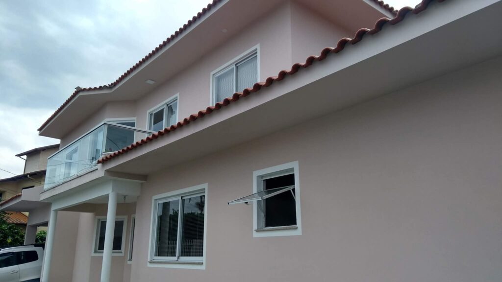 Sobrado com pintura externa em tom claro e detalhes brancos, trabalho da Tribelp Pinturas e Acabamentos.